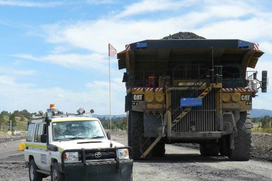 Safety flag pole assembly with flag, pole, and base for vehicle visibility and compliance in mining environments.